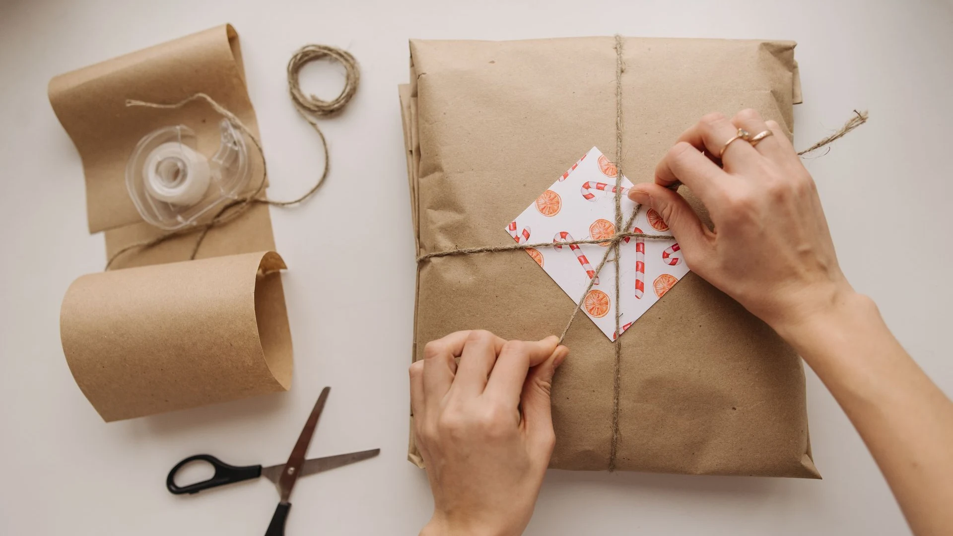 Hands wrapping parcel in kraft paper