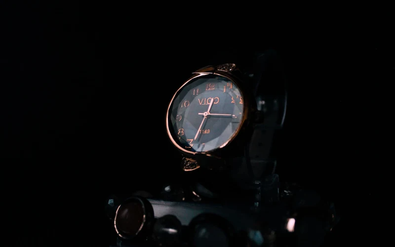 Luxury wristwatch emerging from darkness