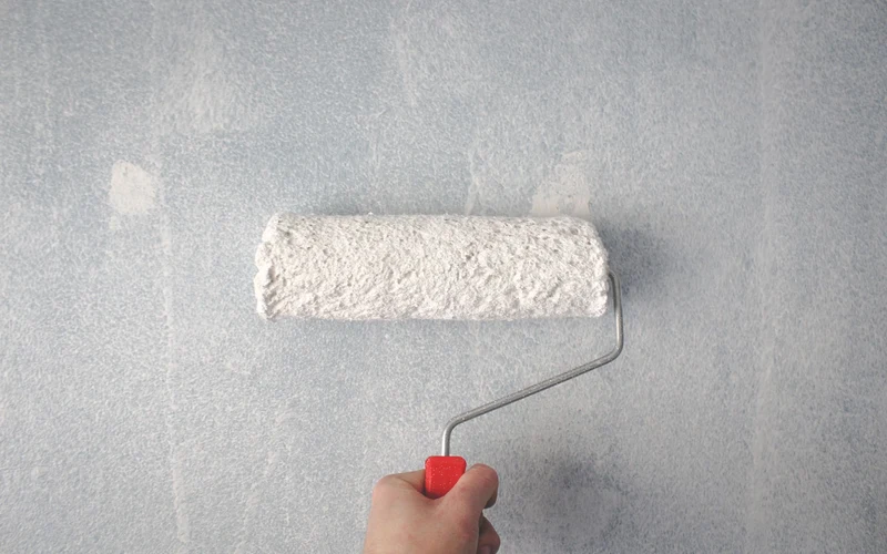 Hand rolling fresh paint on wall
