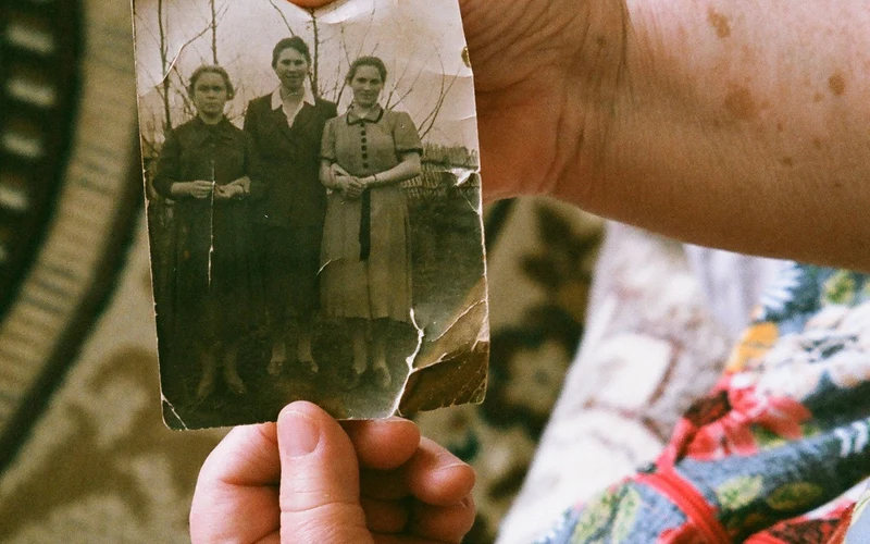 Hands holding a treasured old photograph